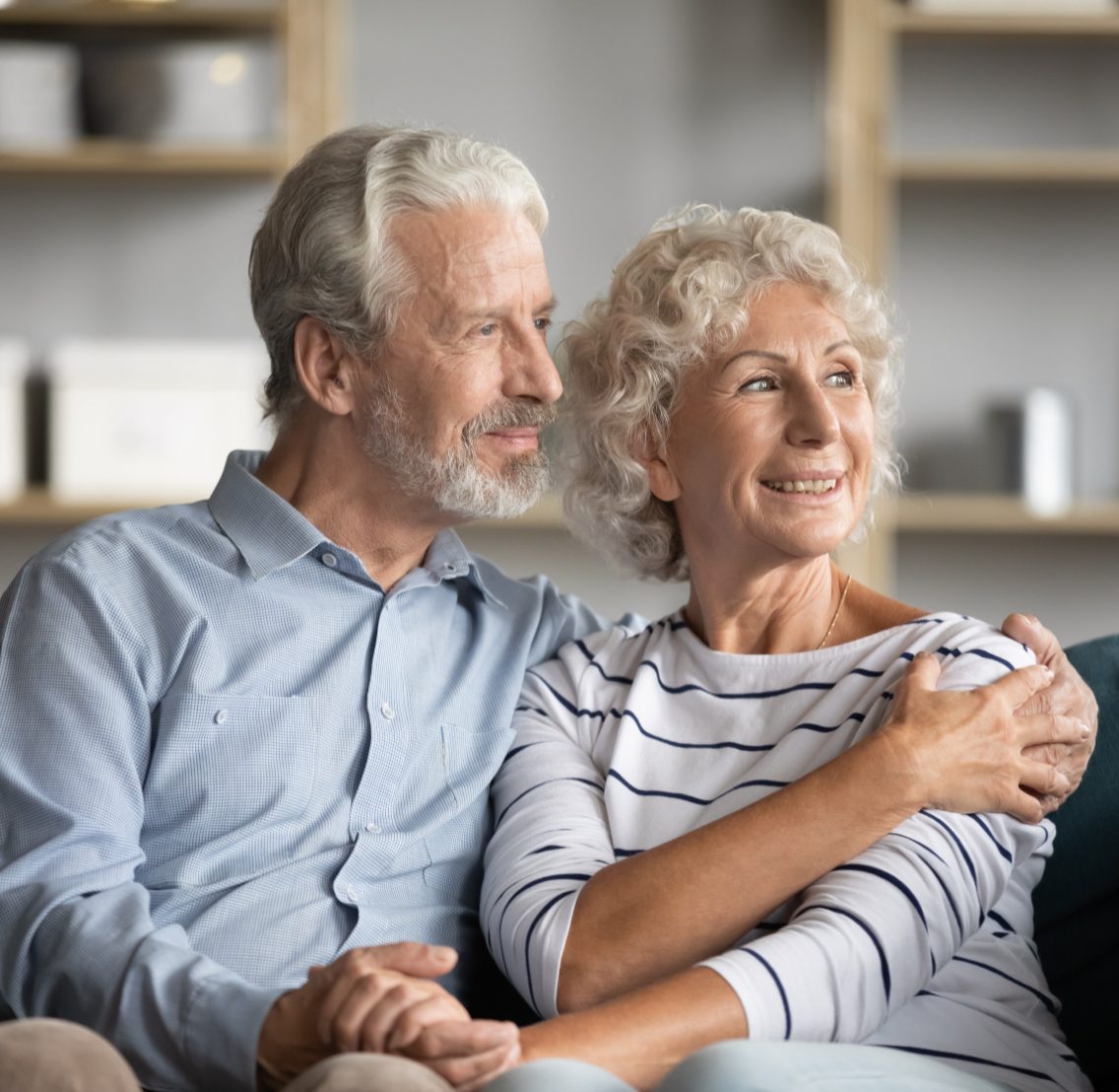 elderly couple holding hands and smiling