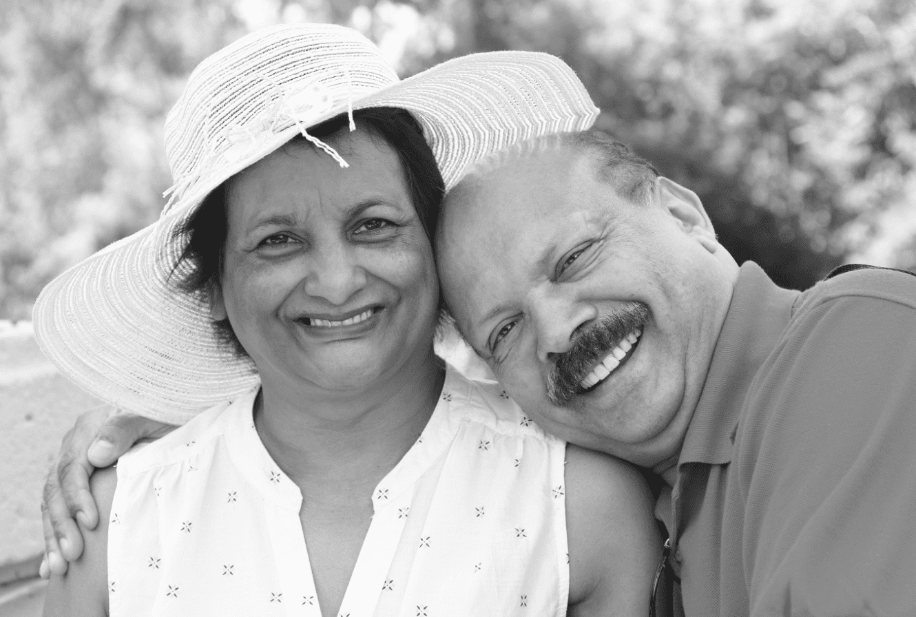 smiling elderly couple holding each other